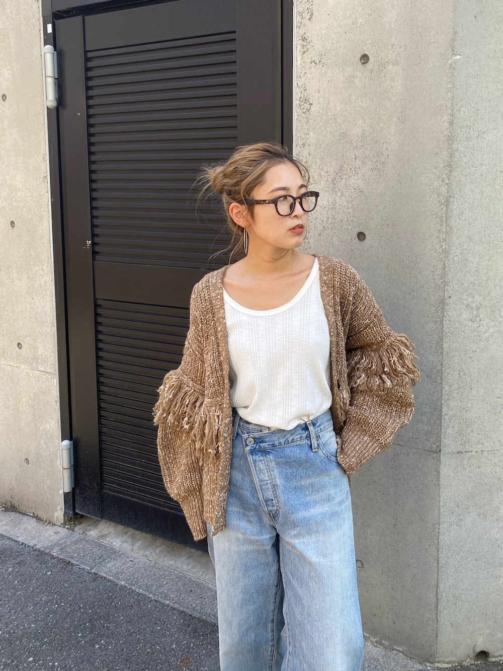 ブラウン系のカーディガン/ボレロ、ブルー系のデニムパンツ、ブラウン系のブーツを着用したレディースの冬コーディネートの3枚目の写真