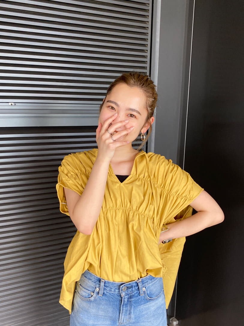 ブルー系のデニムパンツ、イエロー系のシャツ/ブラウス、ブラック系のキャミソールを着用したレディースの夏コーディネートの4枚目の写真