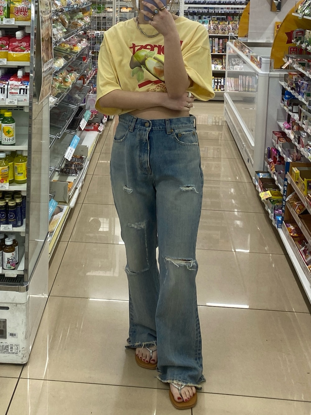 イエロー系のTシャツ/カットソー、ブルー系のデニムパンツを着用したレディースの春コーディネートの3枚目の写真
