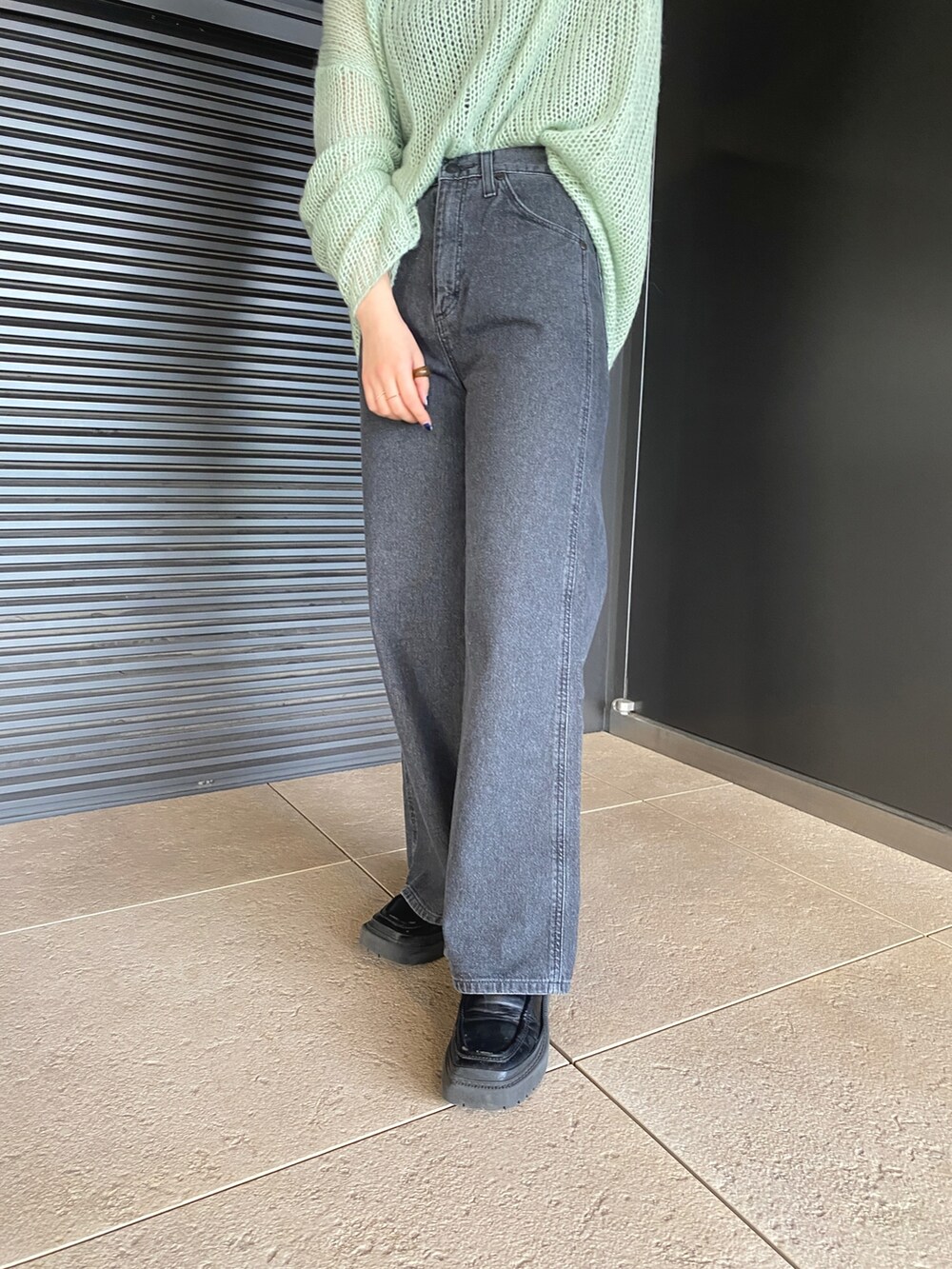 グリーン系のニット/セーター、ブラック系のデニムパンツを着用したレディースの冬コーディネートの7枚目の写真