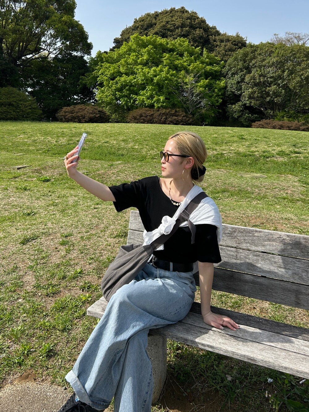 ブラック系のTシャツ/カットソー、ホワイト系のシャツ/ブラウス、グレー系のハンドバッグを着用したレディースの春コーディネートの2枚目の写真