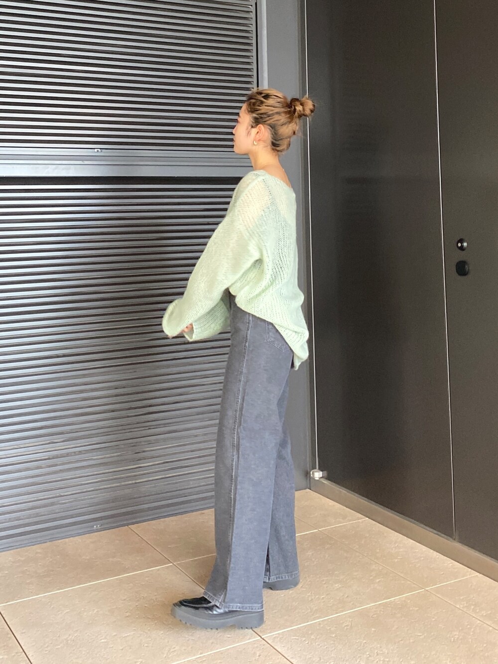 グリーン系のニット/セーター、ブラック系のデニムパンツを着用したレディースの冬コーディネートの3枚目の写真