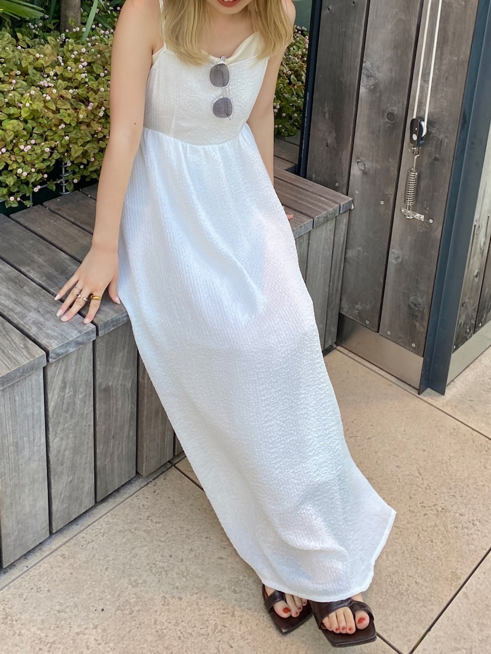 ホワイト系のキャミソール、ホワイト系のワンピース、その他のサンダルを着用したレディースの春コーディネートの6枚目の写真