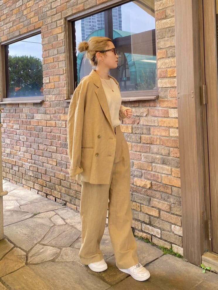 ホワイト系のタンクトップ、ベージュ系のテーラードジャケット、ベージュ系のその他パンツを着用したレディースの春コーディネートの2枚目の写真