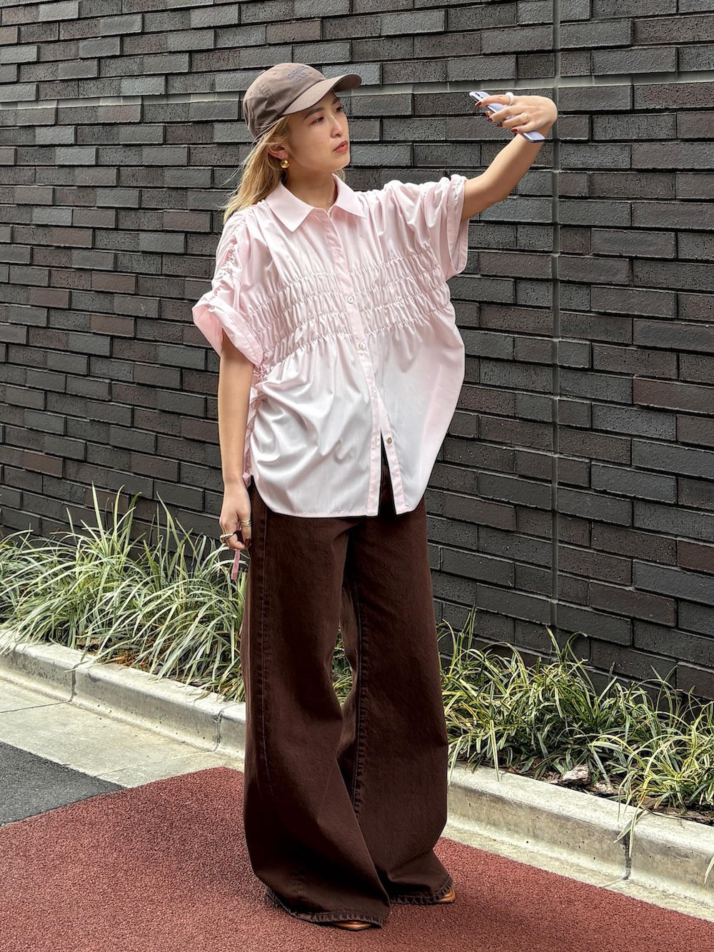 ブラウン系のデニムパンツ、ピンク系のシャツ/ブラウス、その他のサンダルを着用したレディースの春コーディネートの3枚目の写真