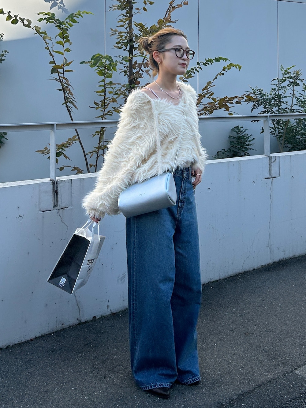 ホワイト系のニット/セーター、ブルー系のデニムパンツを着用したレディースの冬コーディネートの2枚目の写真