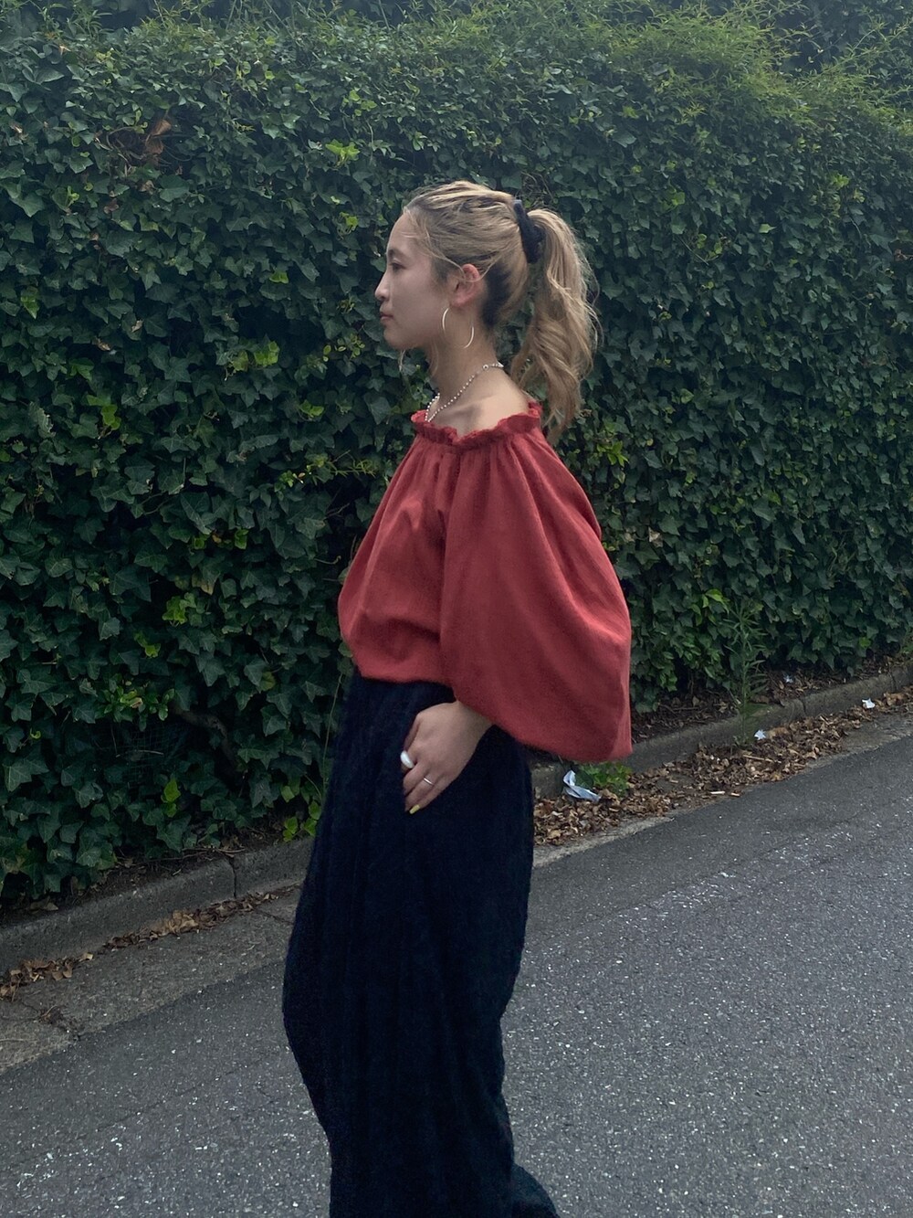 オレンジ系のシャツ/ブラウス、ブラック系のその他パンツを着用したレディースの秋コーディネートの5枚目の写真