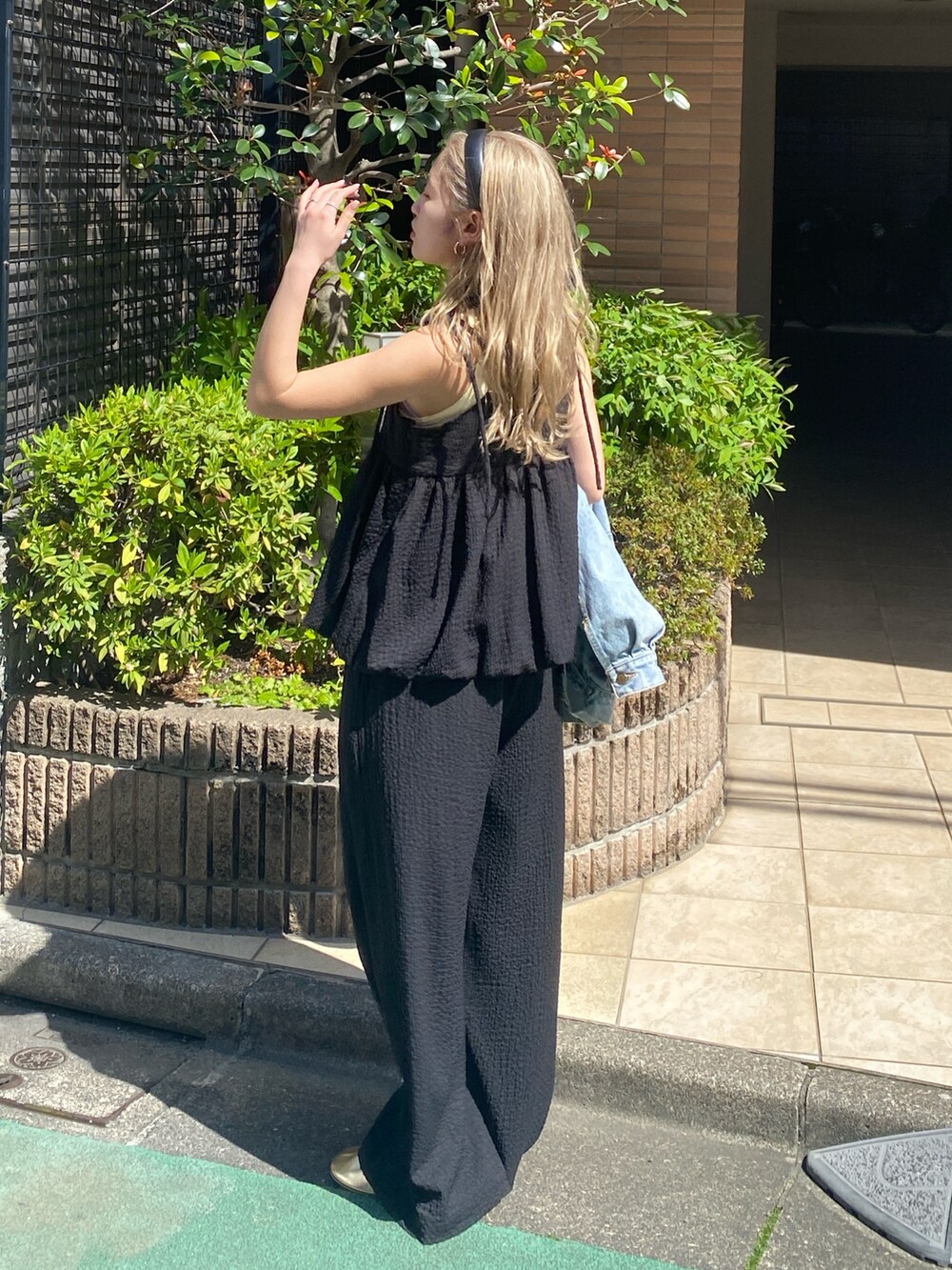 ブラック系のワンピース、イエロー系のタンクトップを着用したレディースの夏コーディネートの4枚目の写真