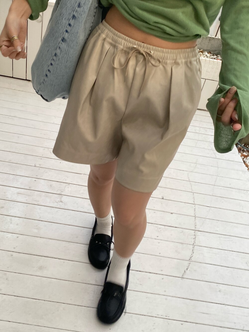 グリーン系のニット/セーター、ベージュ系のその他パンツ、ブラック系のローファーを着用したレディースの冬コーディネートの4枚目の写真