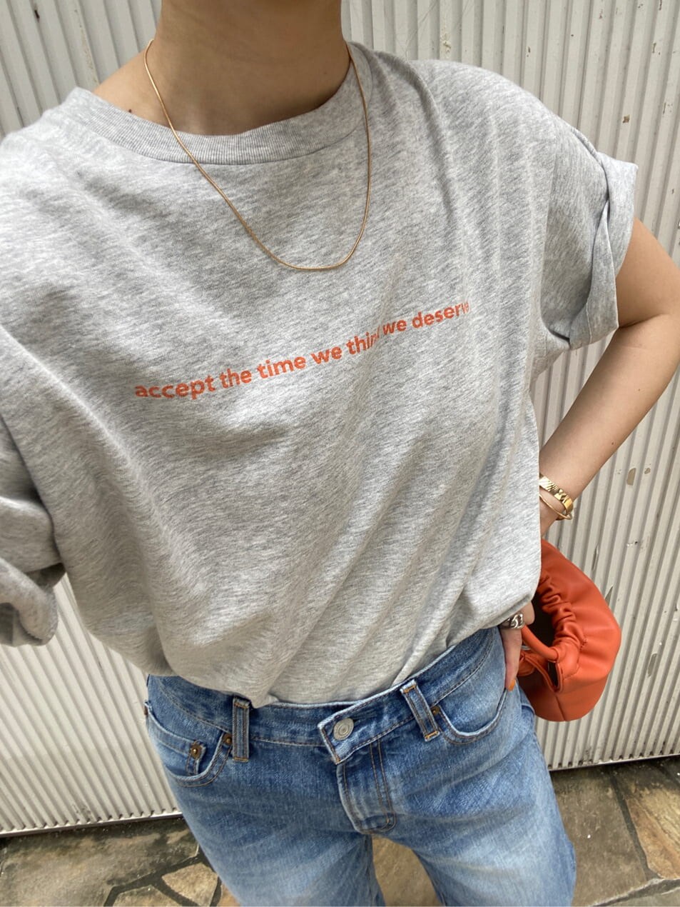 ブルー系のデニムパンツ、ブラック系のサンダル、グレー系のTシャツ/カットソーを着用したレディースの夏コーディネートの5枚目の写真