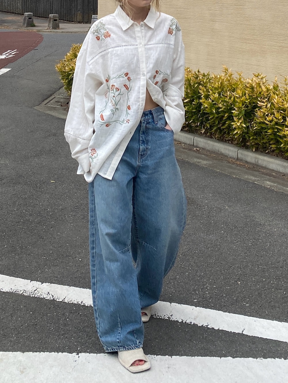 ホワイト系のシャツ/ブラウス、ブルー系のデニムパンツ、ホワイト系のサンダルを着用したレディースの春コーディネートの4枚目の写真