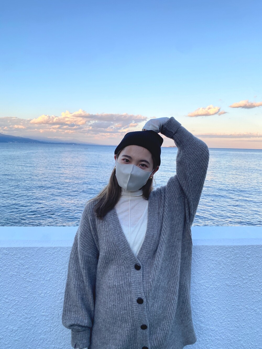 グレー系のカーディガン/ボレロ、ホワイト系のTシャツ/カットソー、ブラック系のニットキャップ/ビーニーを着用したレディースの冬コーディネートの5枚目の写真