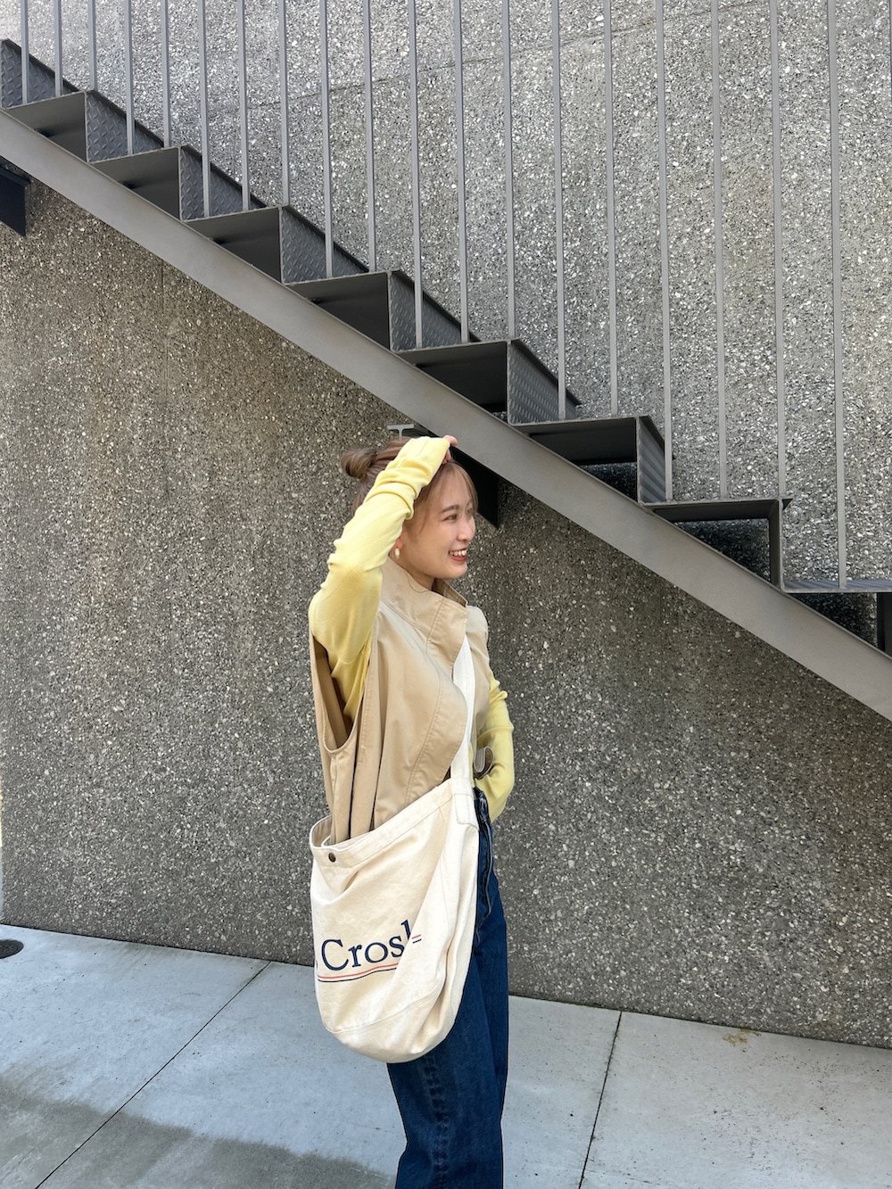 ブルー系のショルダーバッグ、ベージュ系のベスト、グリーン系のTシャツ/カットソーを着用したレディースの夏コーディネートの5枚目の写真