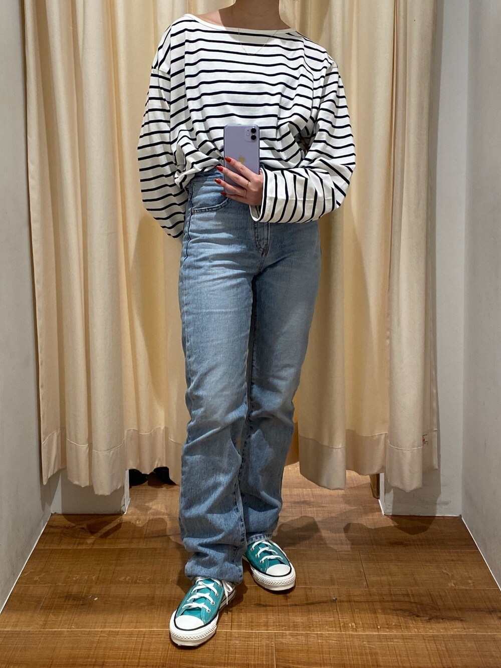 ブルー系のTシャツ/カットソー、ブルー系のデニムパンツ、グリーン系のスニーカーを着用したレディースの冬コーディネートの3枚目の写真