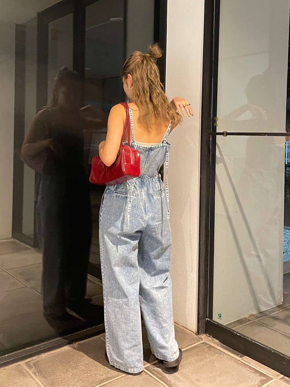 ブルー系のサロペット/オーバーオール、レッド系のハンドバッグ、ホワイト系のキャミソールを着用したレディースの夏コーディネートの2枚目の写真