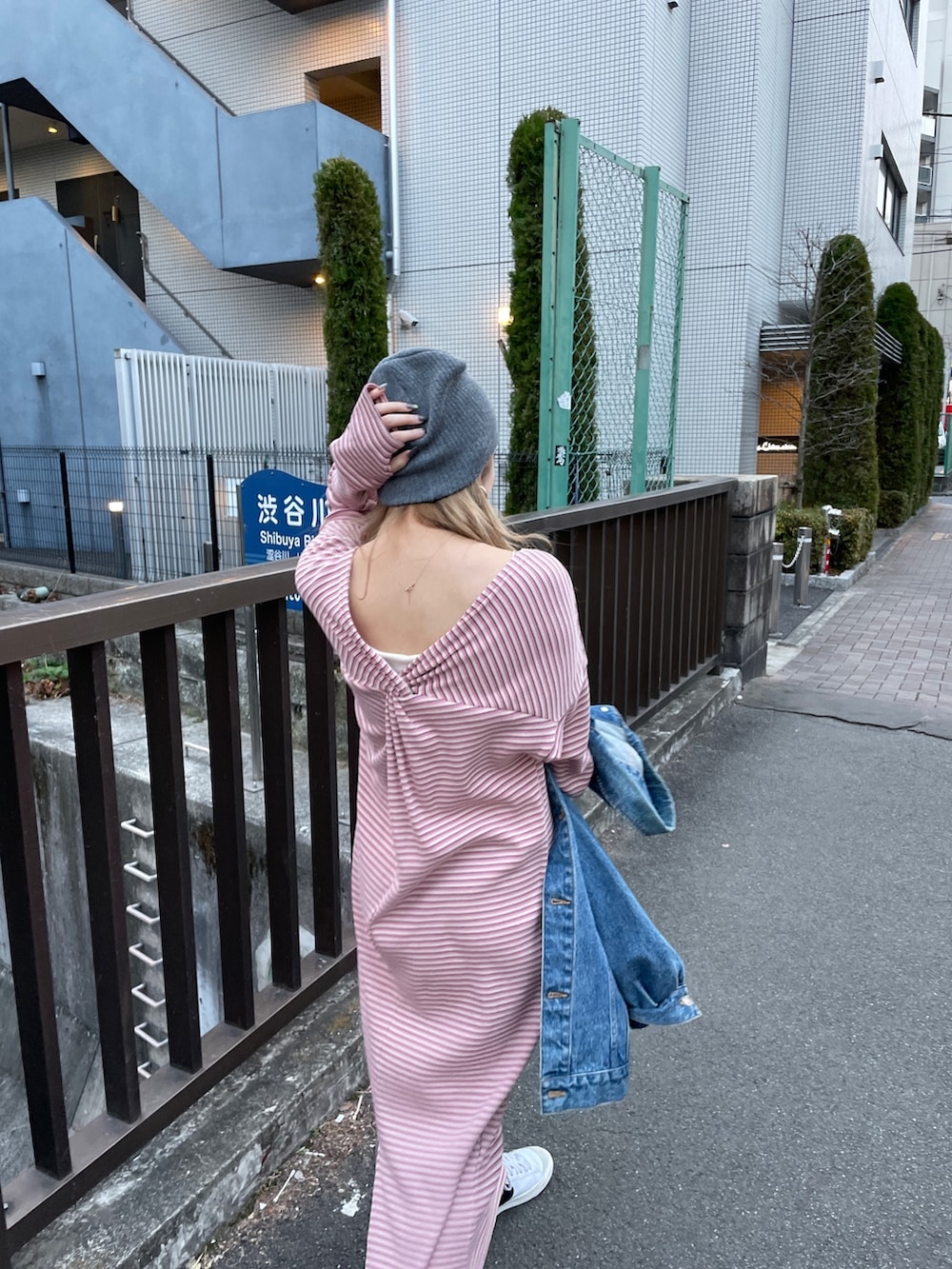 ピンク系のワンピース、ブルー系のデニムジャケット、グレー系のニットキャップ/ビーニーを着用したレディースの冬コーディネートの6枚目の写真