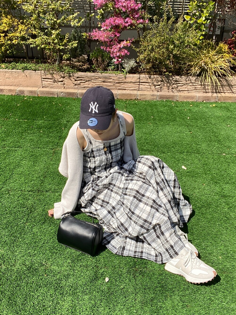 ホワイト系のニット/セーター、ブラック系のワンピース、ブラック系のハンドバッグを着用したレディースの春コーディネートの7枚目の写真