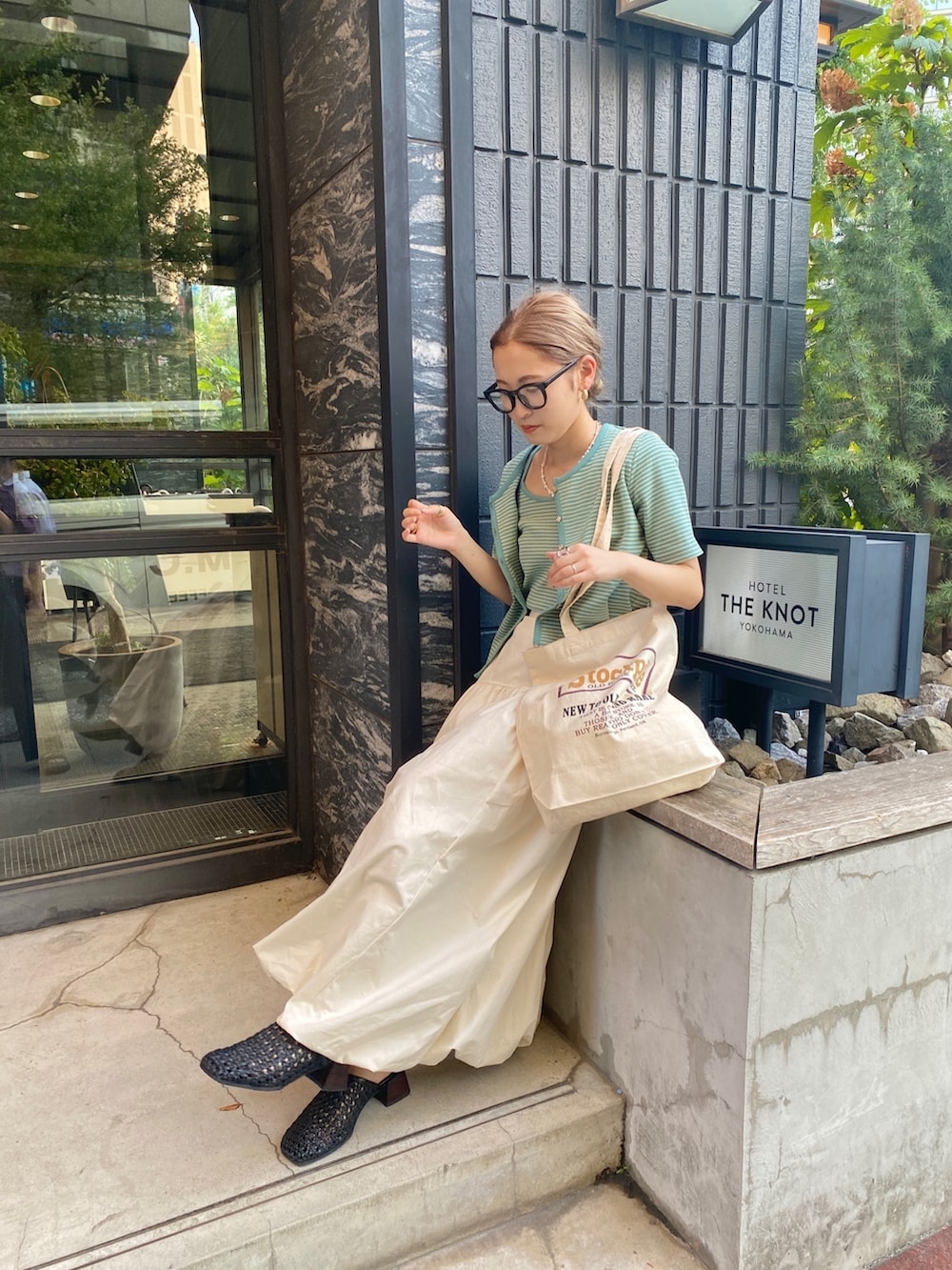 イエロー系のキャミソール、ホワイト系のスカートを着用したレディースの秋コーディネートの3枚目の写真