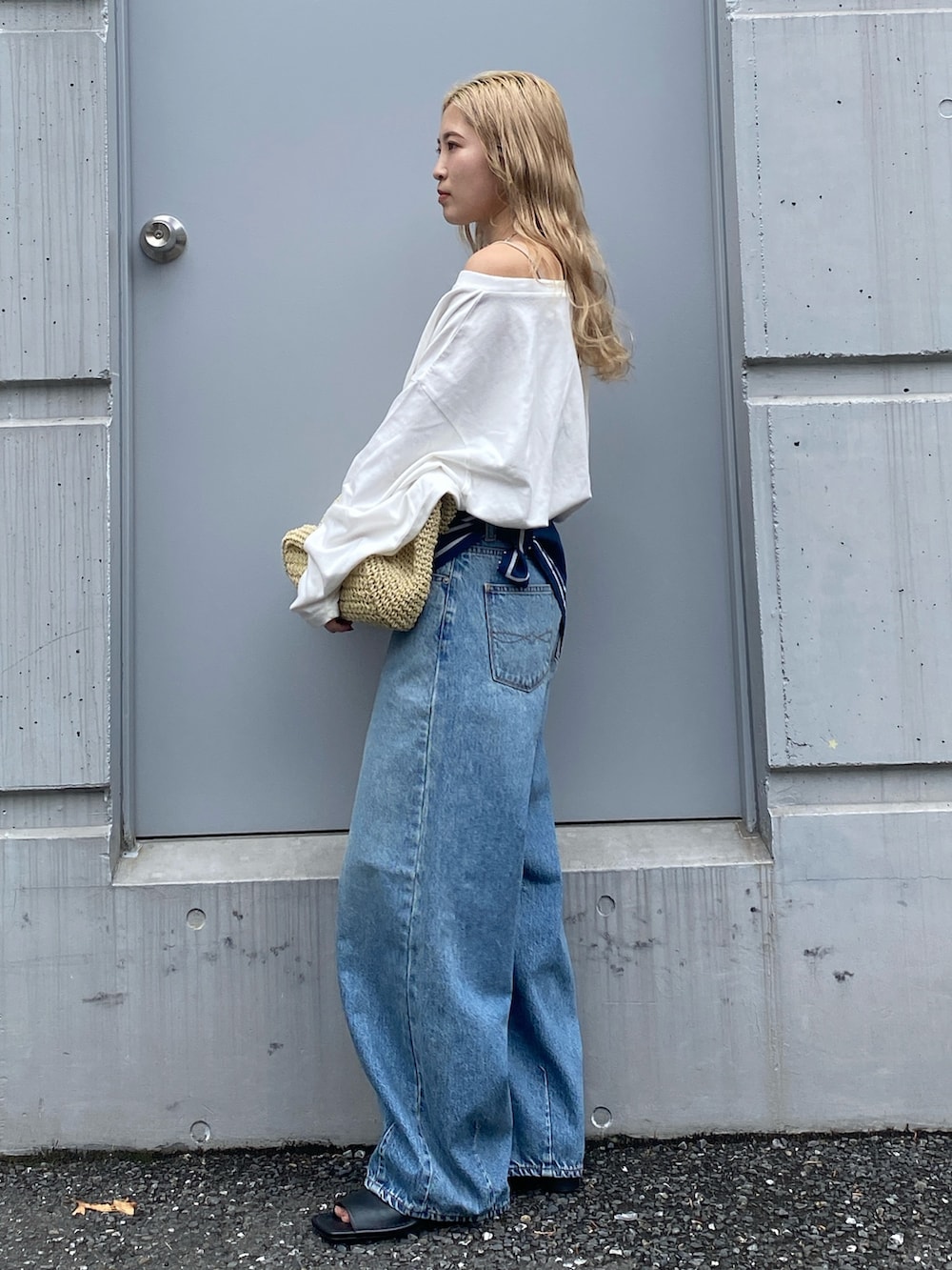 ホワイト系のTシャツ/カットソー、ブルー系のデニムパンツ、ベージュ系のショルダーバッグを着用したレディースの春コーディネートの3枚目の写真