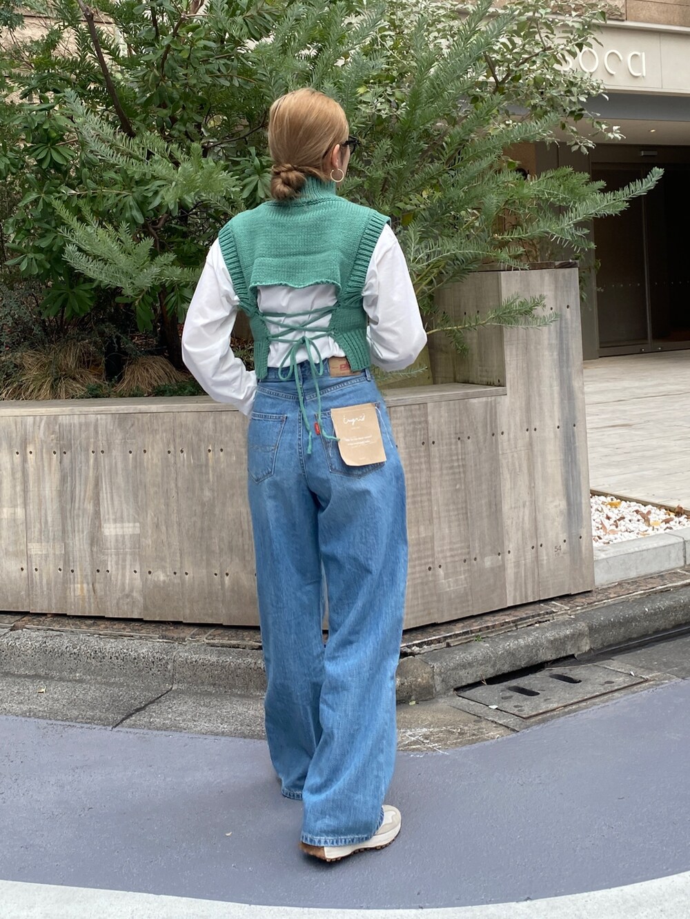 ブルー系のデニムパンツ、グリーン系のワンピースを着用したレディースの冬コーディネートの5枚目の写真