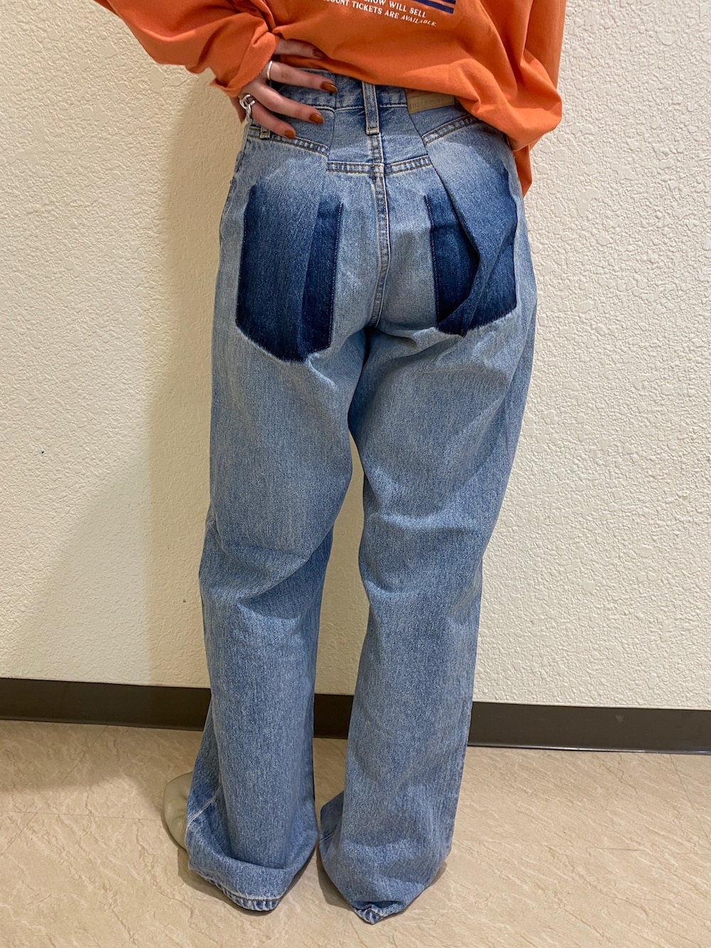 オレンジ系のTシャツ/カットソー、ブルー系のデニムパンツを着用したレディースの冬コーディネートの6枚目の写真