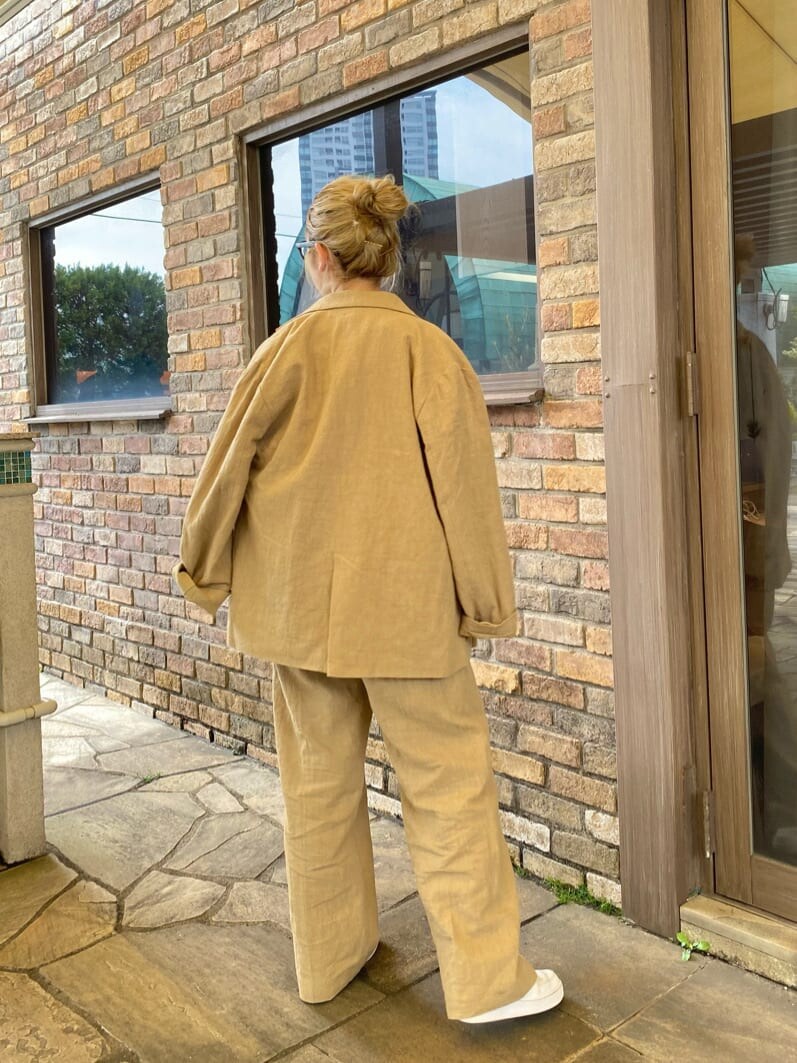 ホワイト系のタンクトップ、ベージュ系のテーラードジャケット、ベージュ系のその他パンツを着用したレディースの春コーディネートの3枚目の写真