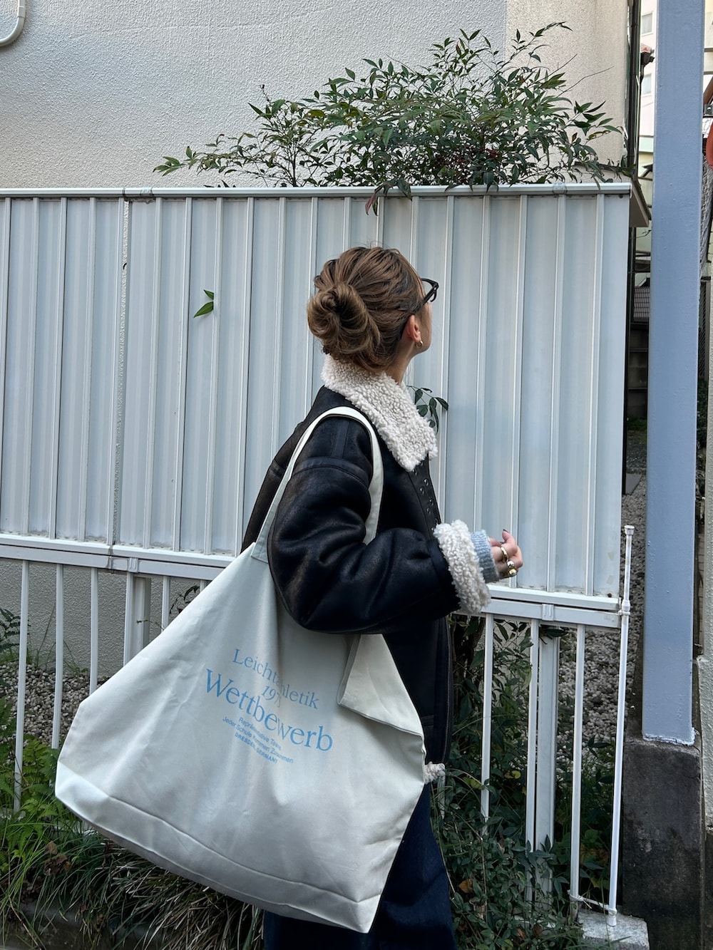 ブラック系のブルゾン、グレー系のカーディガン/ボレロ、ブルー系のデニムパンツを着用したレディースの冬コーディネートの9枚目の写真