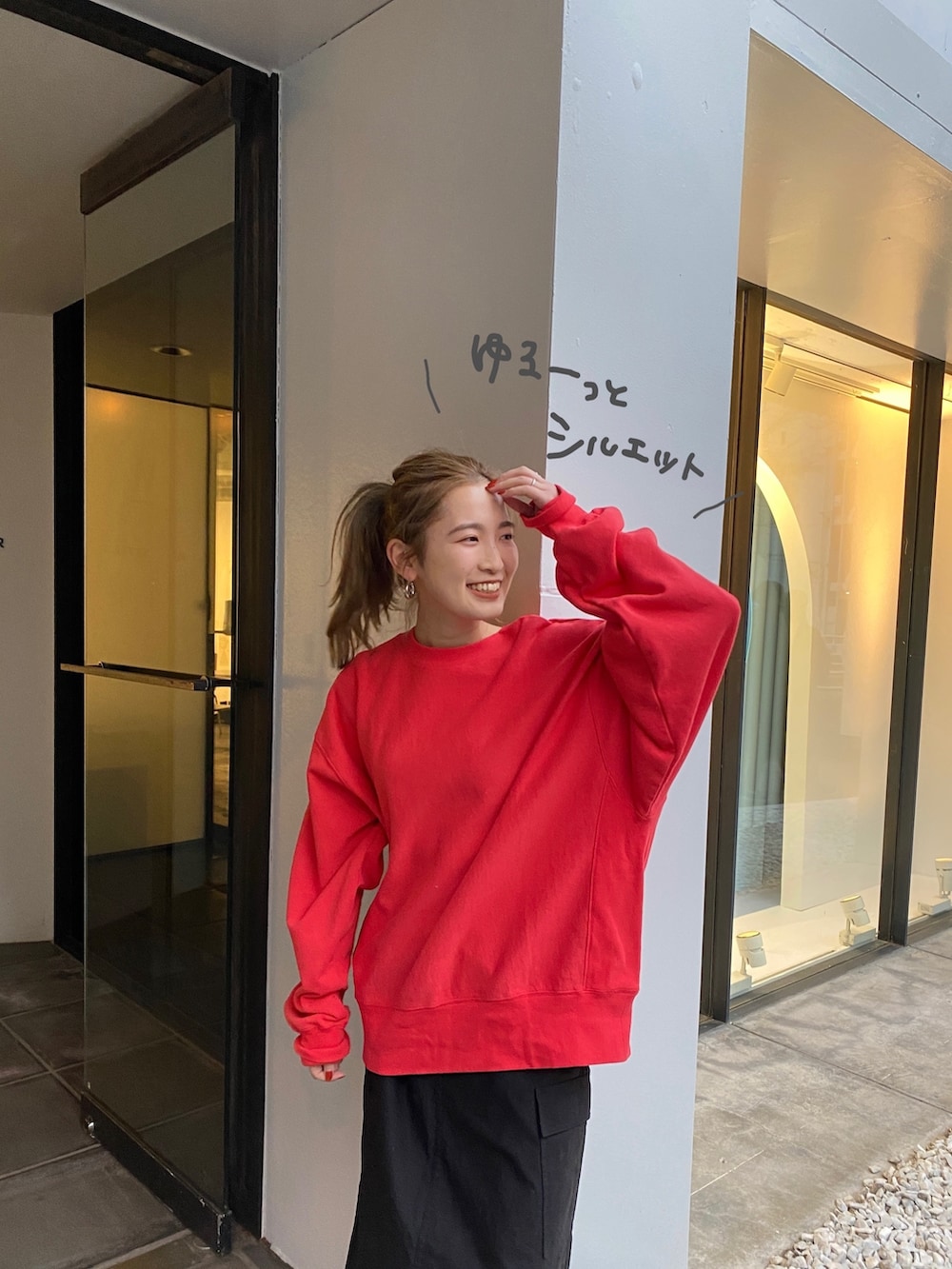 ブルー系のデニムジャケット、レッド系のスウェット、ブラック系のスカートを着用したレディースの冬コーディネートの6枚目の写真