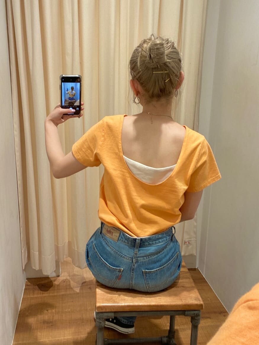 ブルー系のデニムパンツ、ホワイト系のキャミソール、レッド系のハンドバッグを着用したレディースの春コーディネートの4枚目の写真