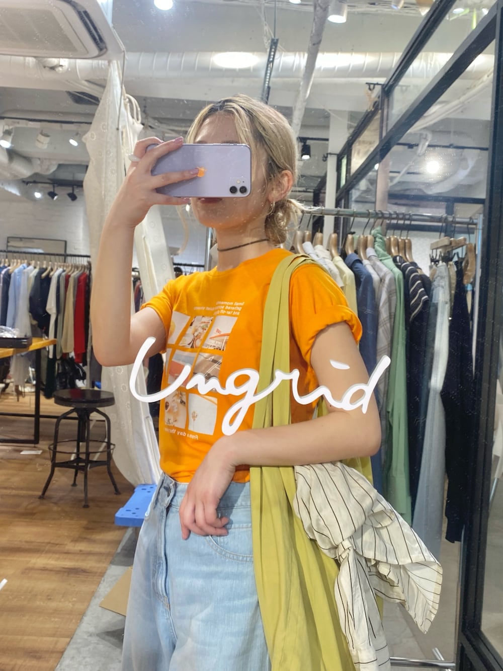 オレンジ系のTシャツ/カットソー、ブルー系のデニムパンツ、その他のサンダルを着用したレディースの春コーディネートの5枚目の写真