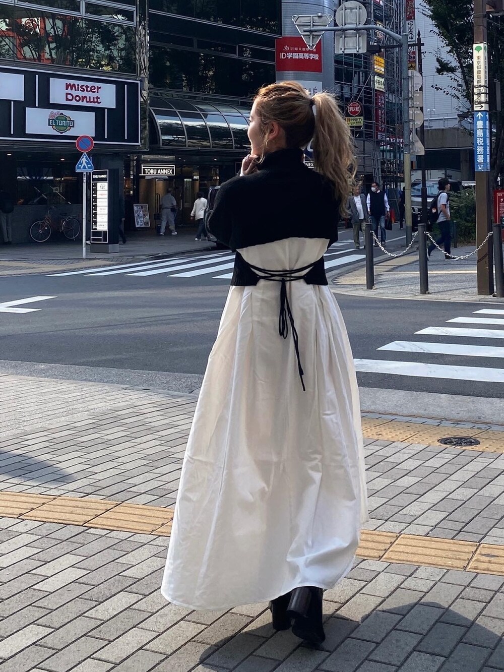 ブラック系のワンピース、その他のチェスターコート、ブラック系のブーツを着用したレディースの冬コーディネートの3枚目の写真