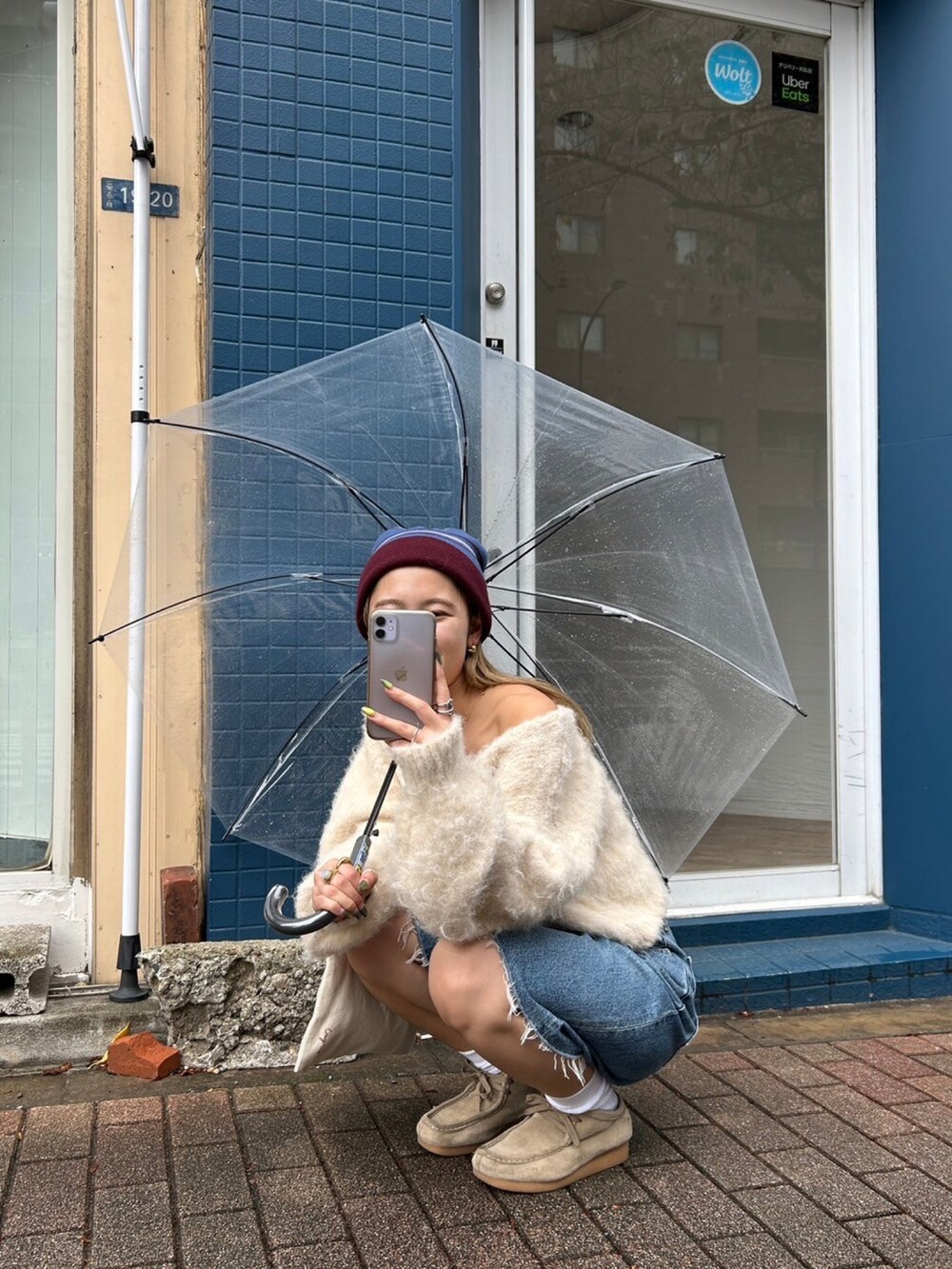 ホワイト系のニット/セーター、ブルー系のデニムパンツ、レッド系のニットキャップ/ビーニーを着用したレディースの秋コーディネートの3枚目の写真