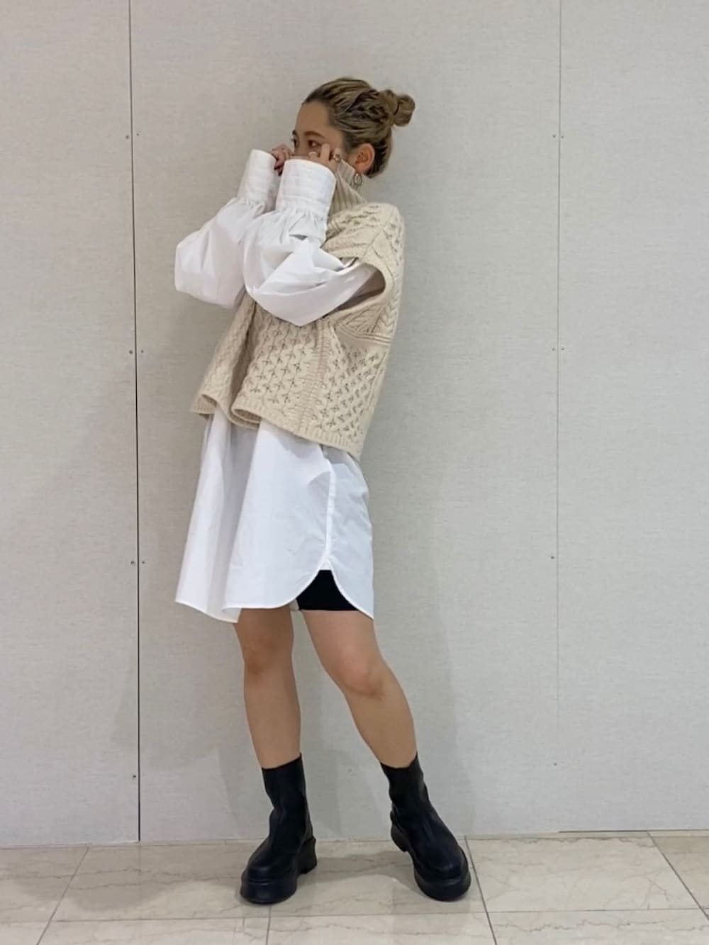 ホワイト系のシャツ/ブラウス、ホワイト系のニット/セーター、ブラック系のブーツを着用したレディースの秋コーディネートの3枚目の写真