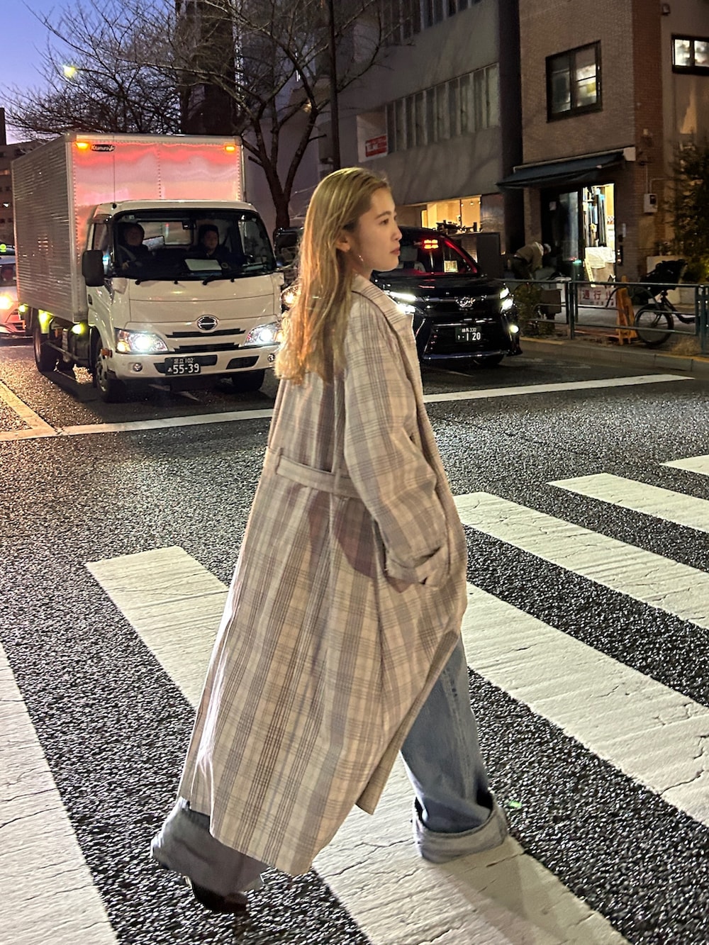 その他のステンカラーコート、ブルー系のデニムパンツ、ピンク系のTシャツ/カットソーを着用したレディースの冬コーディネートの4枚目の写真