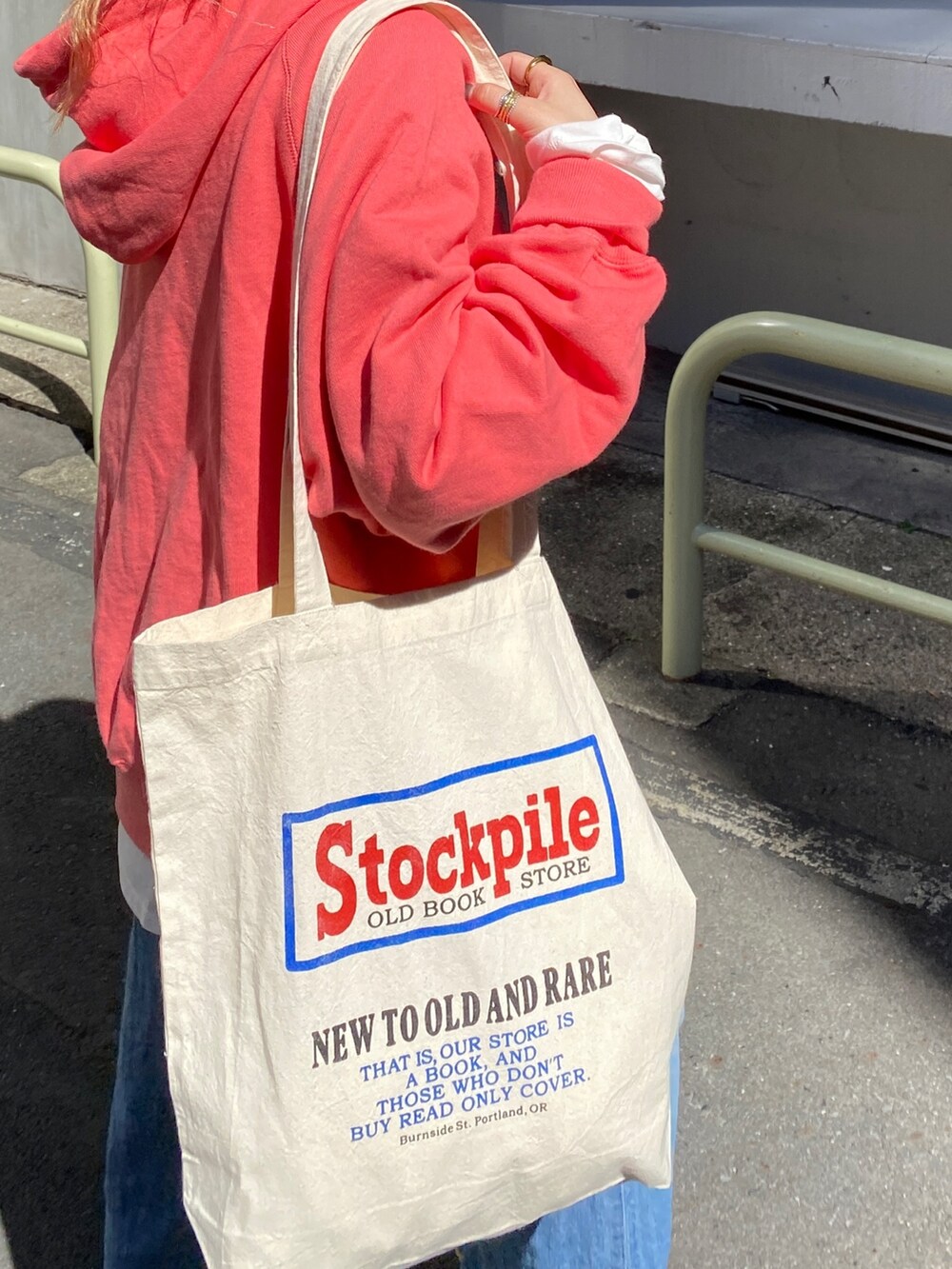 ピンク系のパーカー、ホワイト系のTシャツ/カットソー、ブルー系のデニムパンツを着用したレディースの秋コーディネートの2枚目の写真