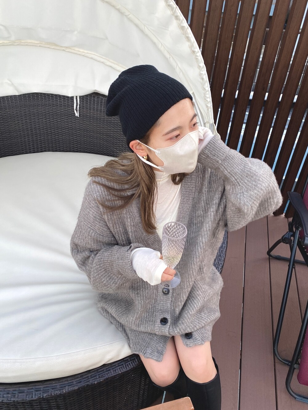 グレー系のカーディガン/ボレロ、ホワイト系のTシャツ/カットソー、ブラック系のニットキャップ/ビーニーを着用したレディースの冬コーディネートの7枚目の写真