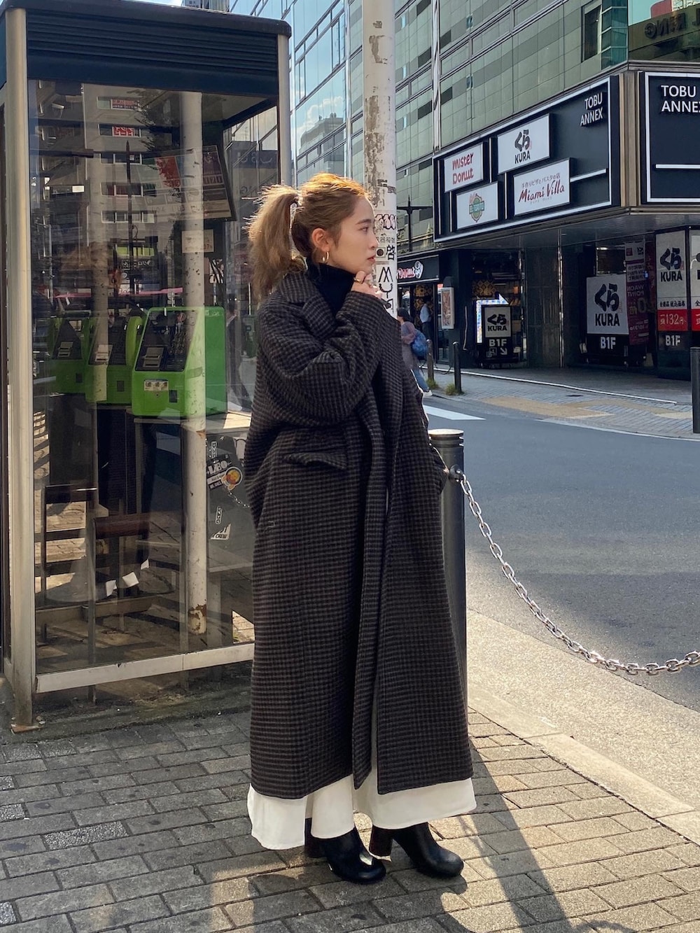 ブラック系のワンピース、その他のチェスターコート、ブラック系のブーツを着用したレディースの冬コーディネートの4枚目の写真