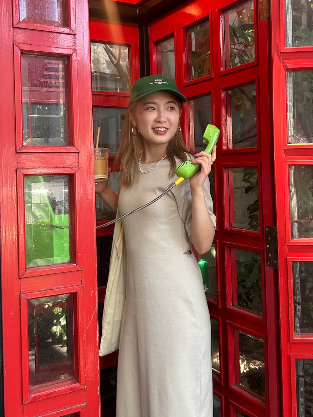 グレー系のワンピース、グリーン系のキャップを着用したレディースの夏コーディネートの3枚目の写真