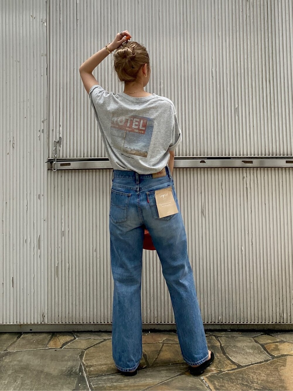 ブルー系のデニムパンツ、ブラック系のサンダル、グレー系のTシャツ/カットソーを着用したレディースの夏コーディネートの4枚目の写真