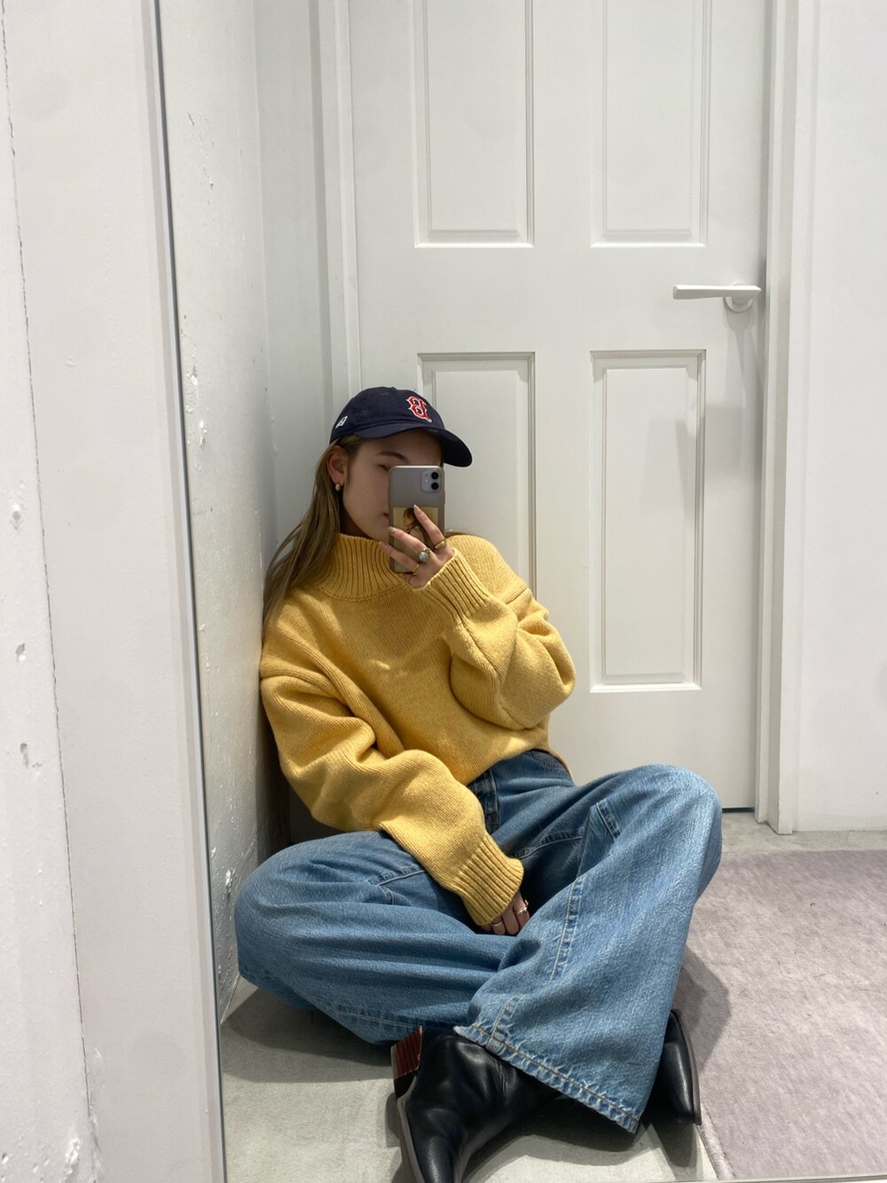 イエロー系のニット/セーター、ブルー系のデニムパンツ、ブラック系のブーツを着用したレディースの冬コーディネートの3枚目の写真