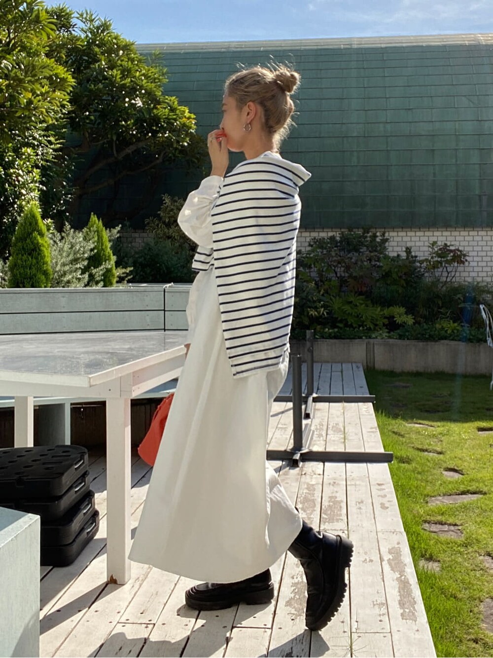 オレンジ系のハンドバッグ、オレンジ系のワンピース、ブルー系のTシャツ/カットソーを着用したレディースの秋コーディネートの3枚目の写真