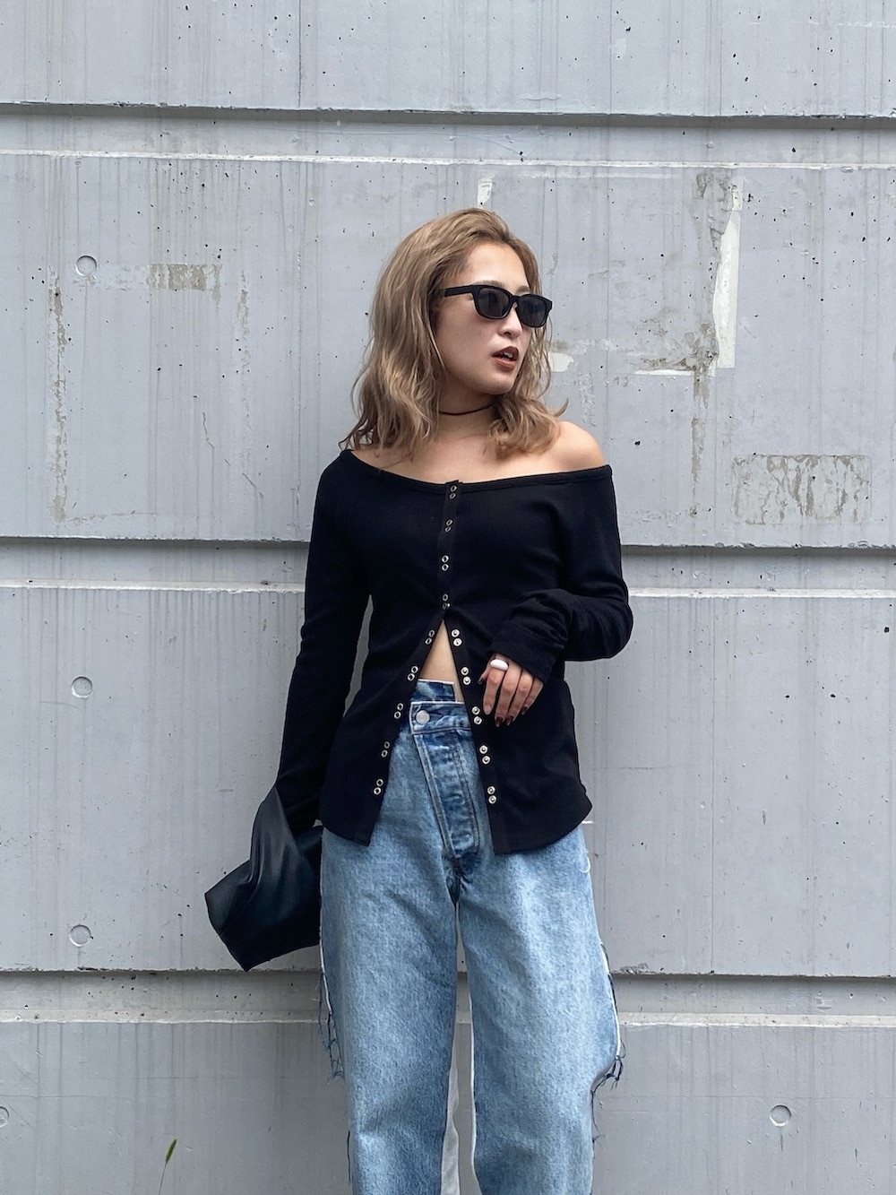 ブラック系のTシャツ/カットソー、ブルー系のデニムパンツ、ブラック系のハンドバッグを着用したレディースの秋コーディネートの4枚目の写真