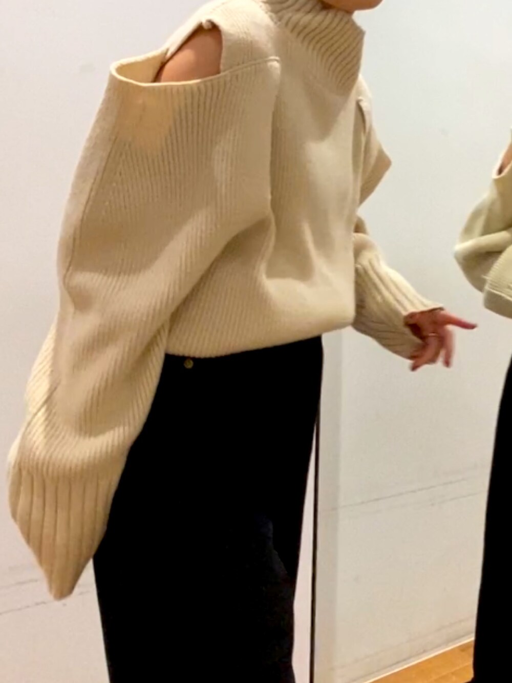 ブラック系のデニムパンツ、ブラック系のブーツ、ホワイト系のニット/セーターを着用したレディースの秋コーディネートの3枚目の写真