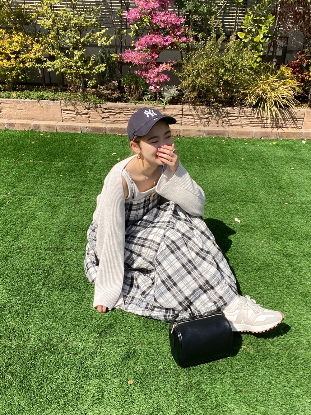 ホワイト系のニット/セーター、ブラック系のワンピース、ブラック系のハンドバッグを着用したレディースの春コーディネートの8枚目の写真