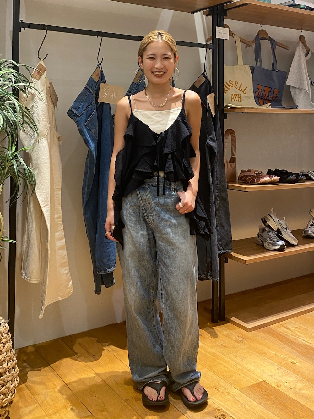 ブラック系のキャミソール、ホワイト系のキャミソール、ブルー系のデニムパンツを着用したレディースの夏コーディネートの2枚目の写真