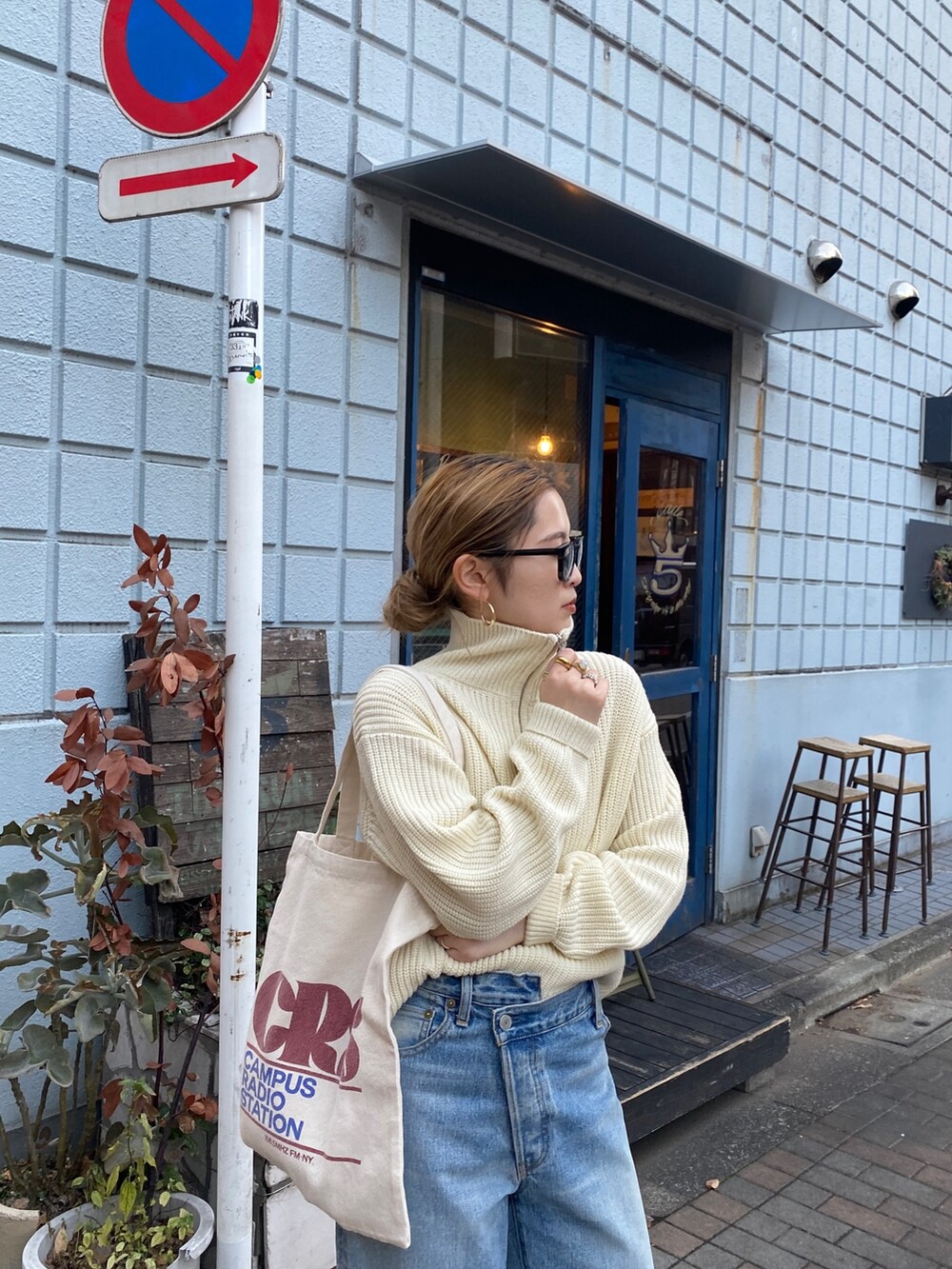 ホワイト系のニット/セーター、ブルー系のデニムパンツ、レッド系のトートバッグを着用したレディースの冬コーディネートの3枚目の写真