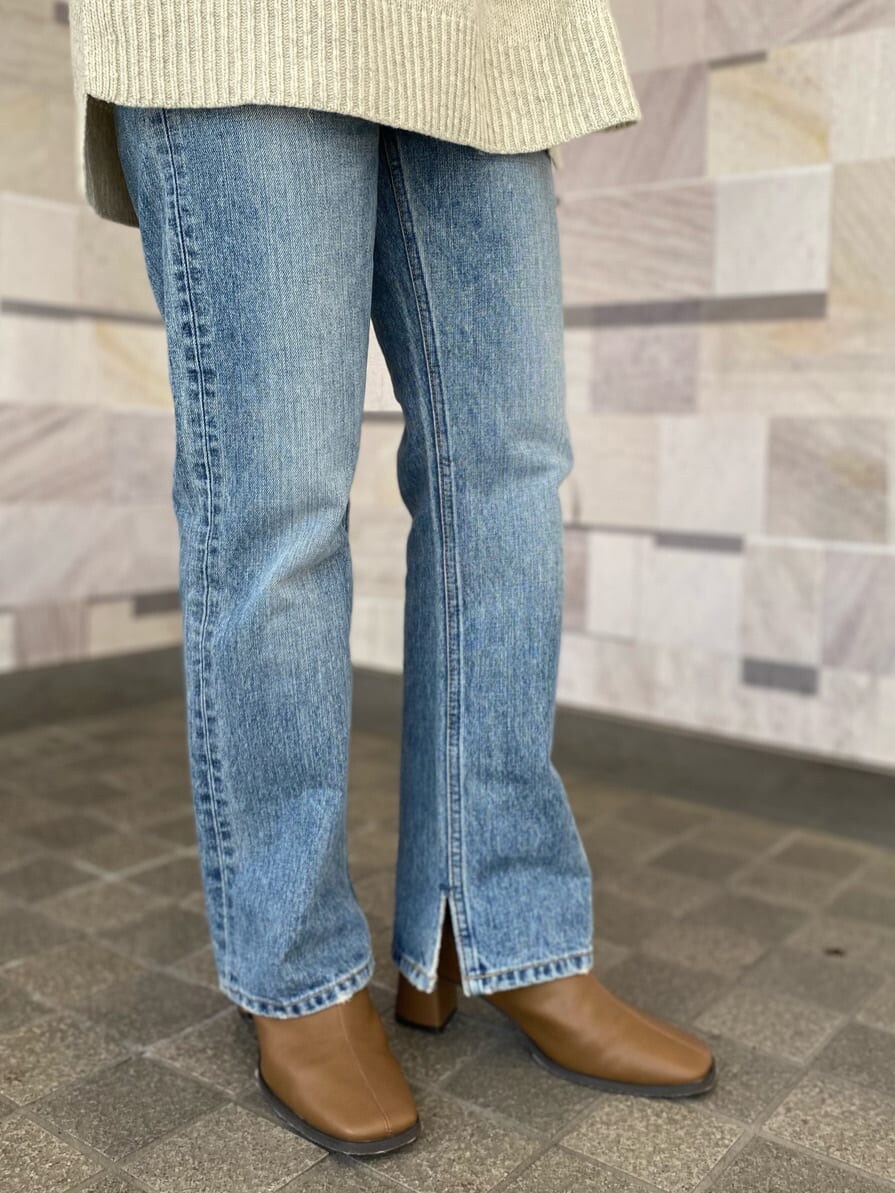 ブルー系のデニムパンツ、ホワイト系のニット/セーター、ホワイト系のTシャツ/カットソーを着用したレディースの冬コーディネートの4枚目の写真