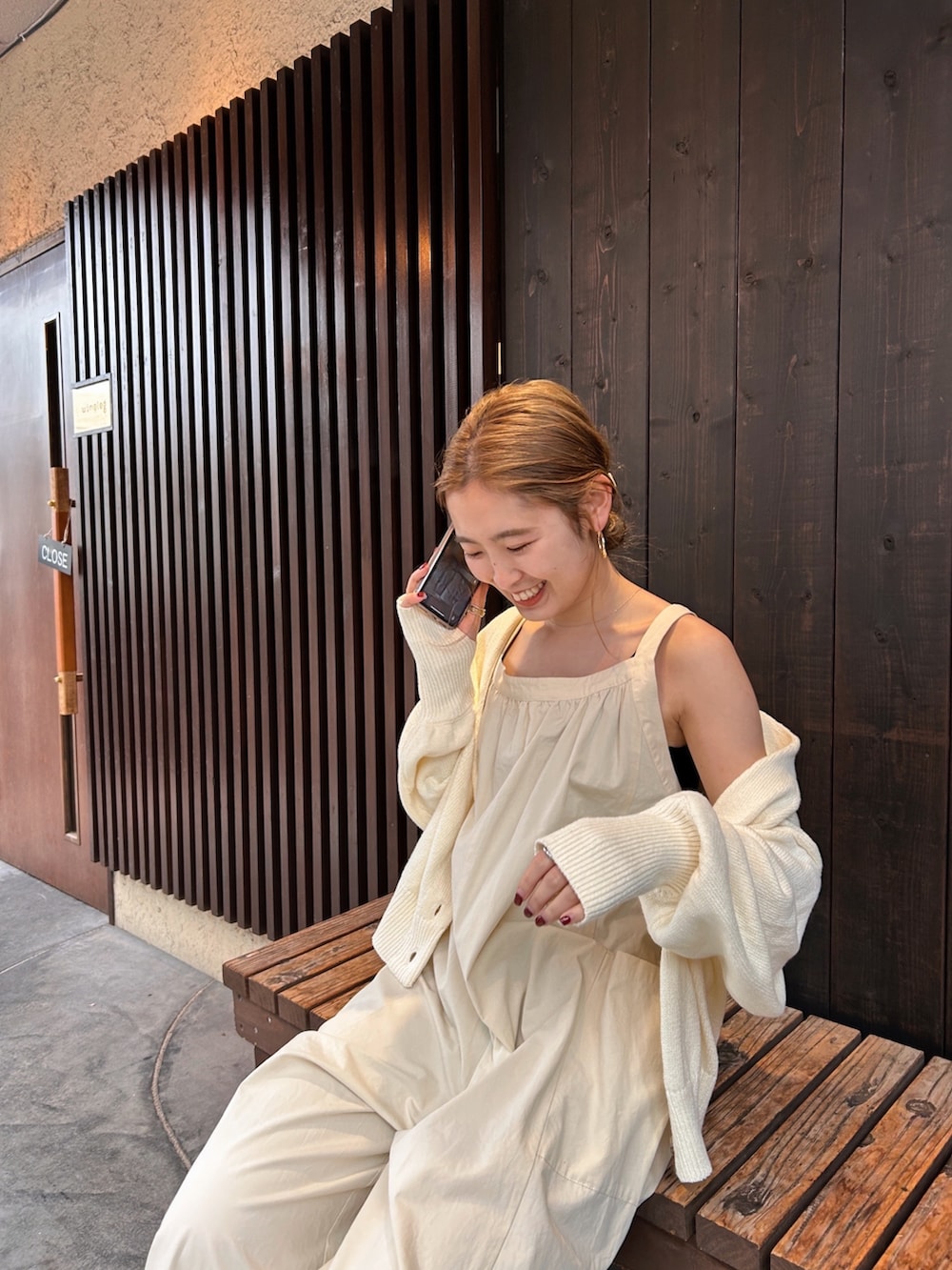 ホワイト系のつなぎ/オールインワン、ホワイト系のカーディガン/ボレロ、ゴールド系のサンダルを着用したレディースの春コーディネートの2枚目の写真