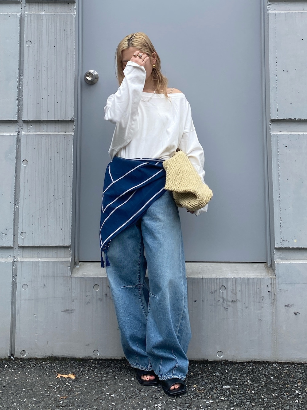 ホワイト系のTシャツ/カットソー、ブルー系のデニムパンツ、ベージュ系のショルダーバッグを着用したレディースの春コーディネートの2枚目の写真