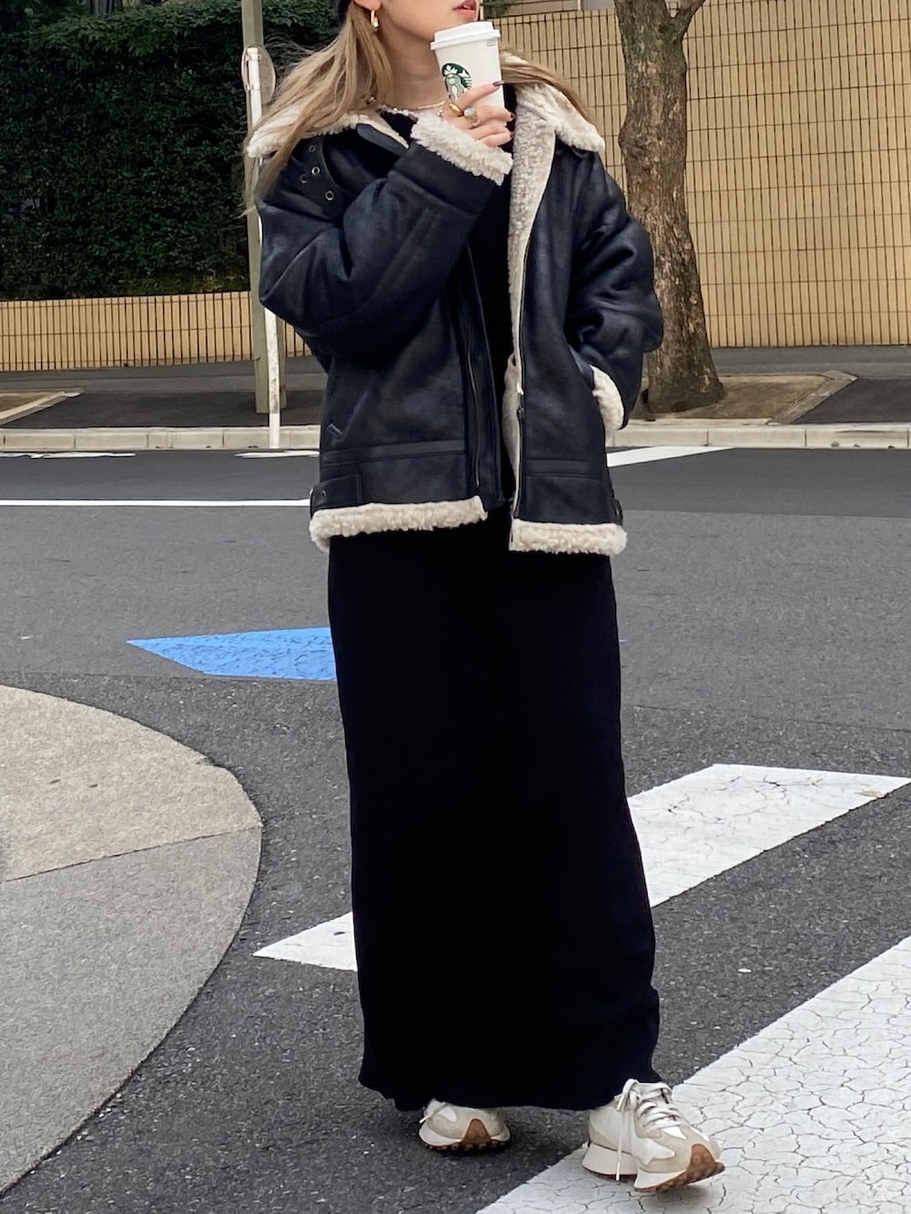 ブラック系のムートンコート、ブラック系のワンピース、ブラック系のニットキャップ/ビーニーを着用したレディースの冬コーディネートの3枚目の写真